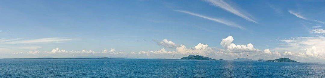 Panoramic mural of islands in ocean under clouds, ideal for indoor and outdoor spaces.