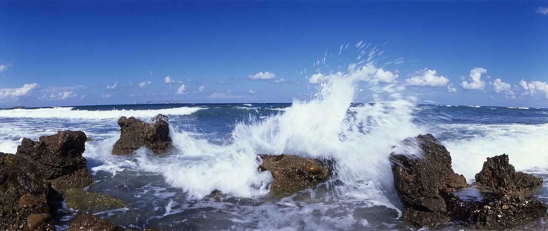 Wave crashing on volcanic rock mural, ideal for indoor and outdoor spaces.
