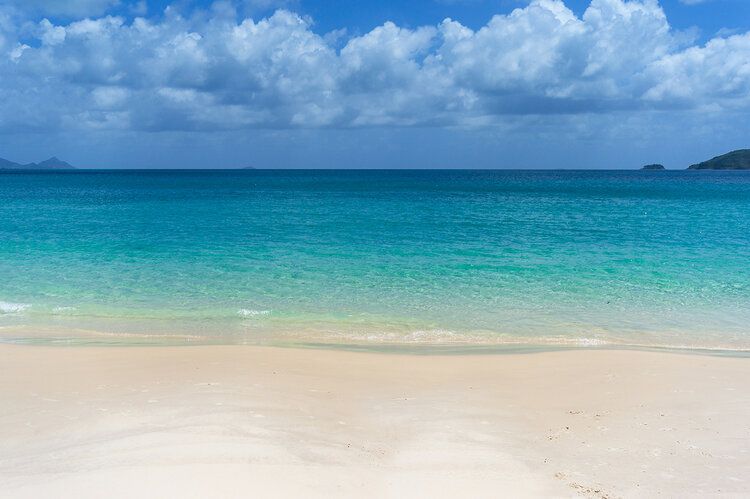 Tropical beach mural with white sand and clear water, perfect for indoor and outdoor spaces.