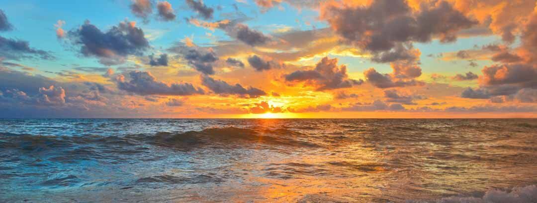 Serene mural of sunset over ocean waves, ideal for tranquil indoor and outdoor spaces.