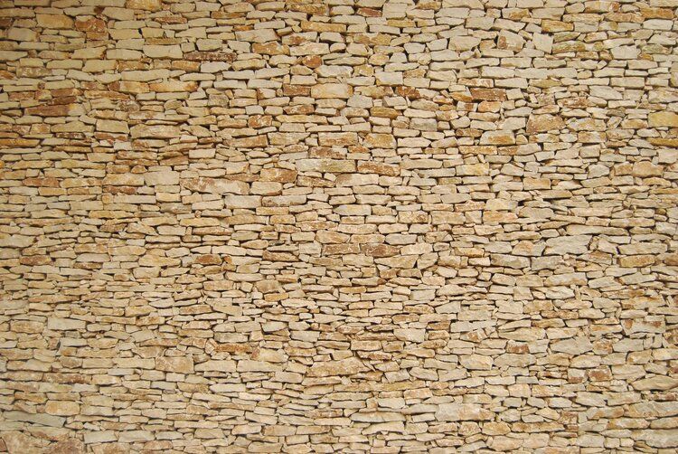 Light-colored stacked stone wall mural, ideal for adding elegance to indoor and outdoor spaces.