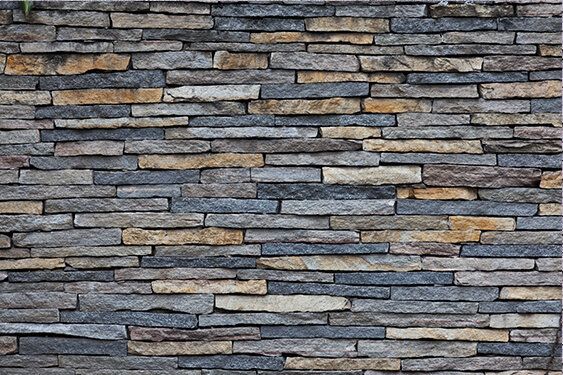 Gray and yellow stone wall mural, ideal for enhancing indoor and outdoor spaces.