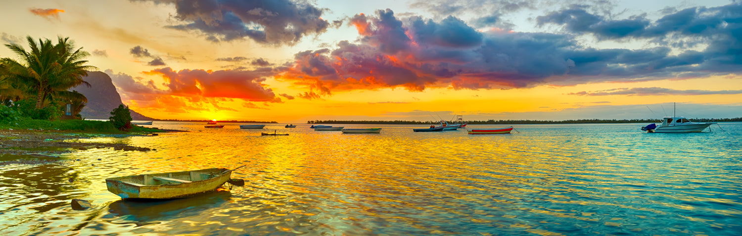 Panoramic mural of fishing boat at sunset with Le Morne Brabant, ideal for any space.