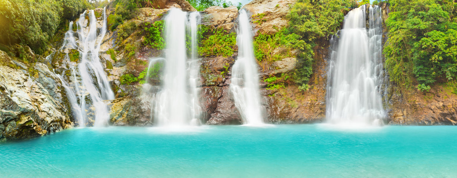 Panoramic waterfall mural with lush greenery, ideal for indoor and outdoor spaces.